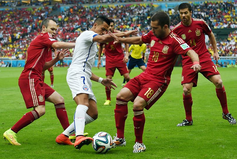 Chile's Alexis Sanchez attempts to dribble past Spain's Jordi Alba and Andres Iniesta - Spain 0 vs. 2 Chile