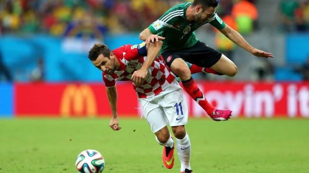 2014 FIFA World Cup - Croatia captain Darijo Srna challenges Mexico's Miguel Layun for the ball.