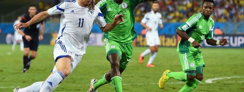 Edin Dzeko of Bosnia and Herzegovina and Kenneth Omeruo of Nigeria compete for the ball during the 2014 FIFA World Cup