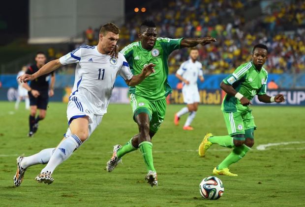 Edin Dzeko of Bosnia and Herzegovina and Kenneth Omeruo of Nigeria compete for the ball during the 2014 FIFA World Cup