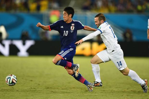 2014 FIFA World Cup - Japan's Shinji Kagawa dribbles past Greece's Dimitrios Salpingidis.